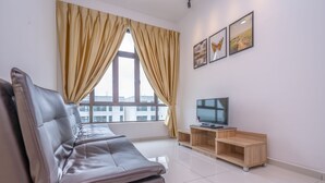 A modern living room with a leather sofa, a TV on a wooden stand, and large windows with curtains. - OYO Home 89458 Amazing 2br D'summit (Johor Bahru)