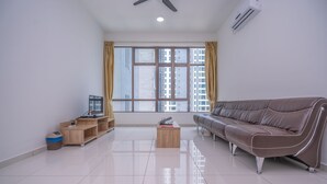 A modern living room with a leather sofa, a wooden coffee table, and a TV on a wooden stand. - OYO Home 89458 Amazing 2br D'summit (Johor Bahru)