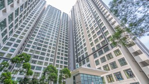 A high-rise building with multiple floors, large windows, and some greenery in the foreground. - OYO Home 89458 Amazing 2br D'summit (Johor Bahru)