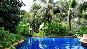 A swimming pool surrounded by lush tropical vegetation. - Kata Gardens 2br Holiday Apartment 8A (Karon)