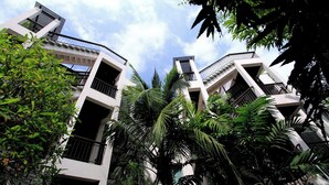 A modern building with multiple balconies and a lush green garden. - Kata Gardens 2br Holiday Apartment 8A (Karon)