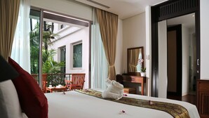 A hotel room with a bed, a desk, a chair, and a view of the outside.