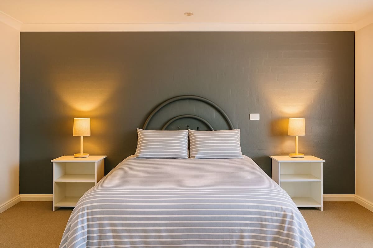 Quarto com uma cama, duas mesas de cabeceira e uma cabeceira.