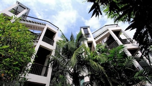 A modern building with multiple balconies and a lush green garden. - Kata Gardens Rooftop Plunge Pool Penthouse 4C (Karon)