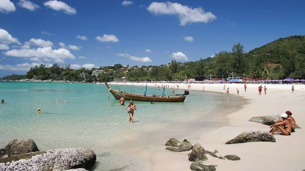 A beach with clear turquoise water, a boat, and people enjoying the shore. - Kata Gardens Rooftop Plunge Pool Penthouse 4C (Karon)