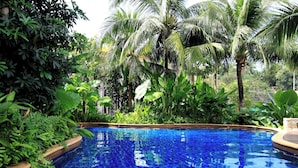 Une piscine entourée d’une végétation tropicale luxuriante.