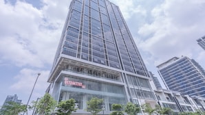 Ein modernes Hochhaus mit Glasfassade und einem auffälligen 'RENT'-Schild, das ein Angebot bewirbt.