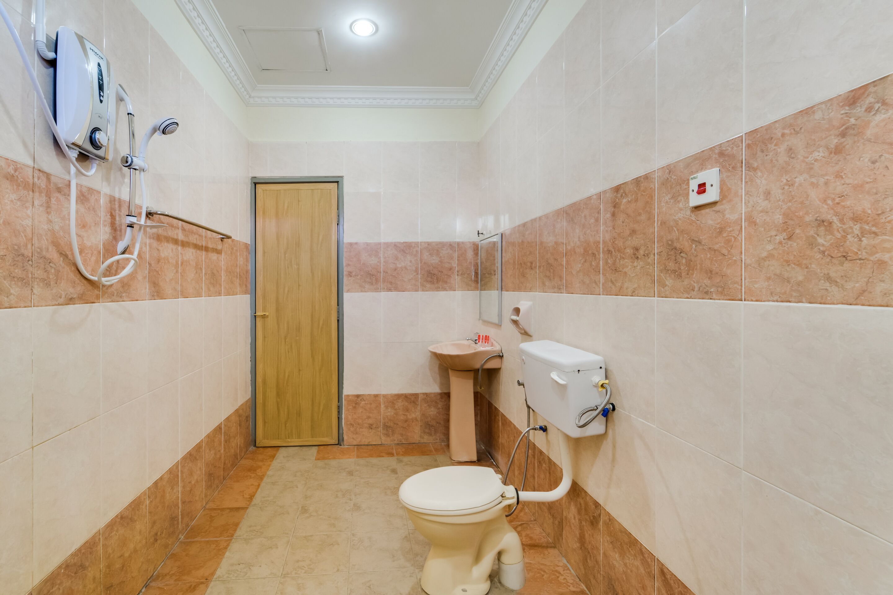 A small bathroom with a toilet, sink, and shower.