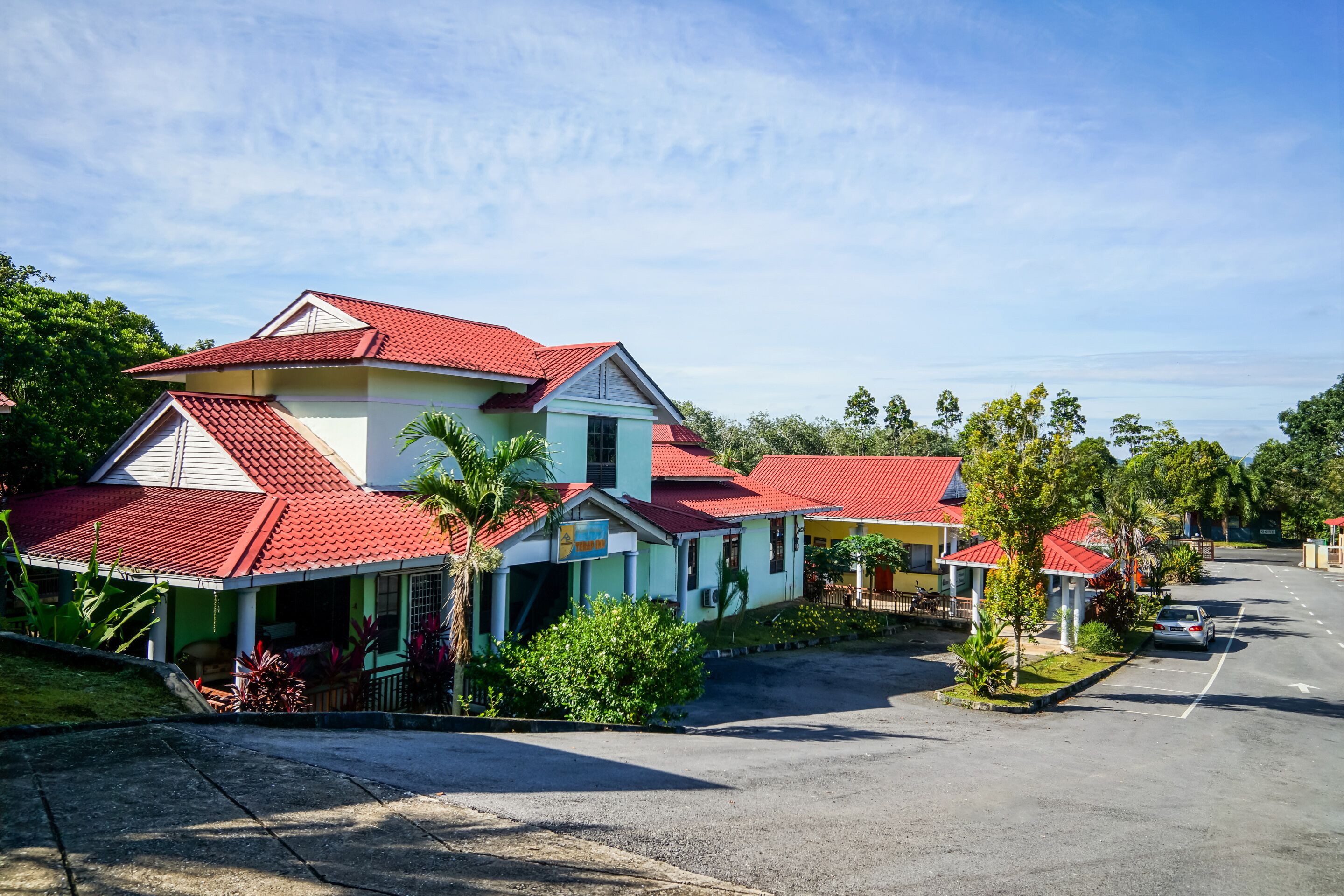 A residential area with houses featuring red roofs and light blue walls.