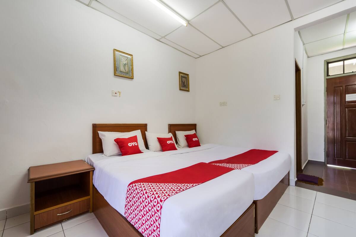 Hotellihuone, jossa on suuri sänky, kaksi yöpöytää ja puinen vaatekaappi.