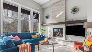 Una sala de estar moderna con un sofá azul, una mesa de centro y una chimenea.