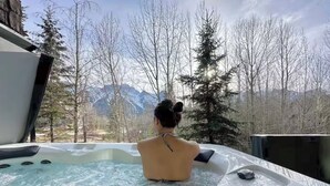 Una persona en un jacuzzi con vistas a las montañas.