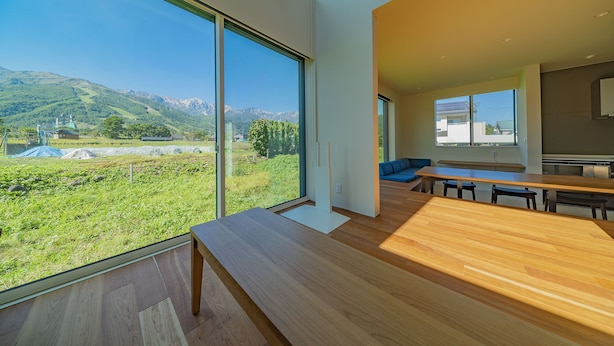 Un interior moderno con un ventanal grande que ofrece vistas a un paisaje verde y montañas.