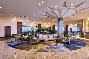 A spacious lobby with a central seating area, a large pillar, and a modern ceiling design. - ANA Crowne Plaza Resort Okinawa Uruma Hills by IHG (Uruma)