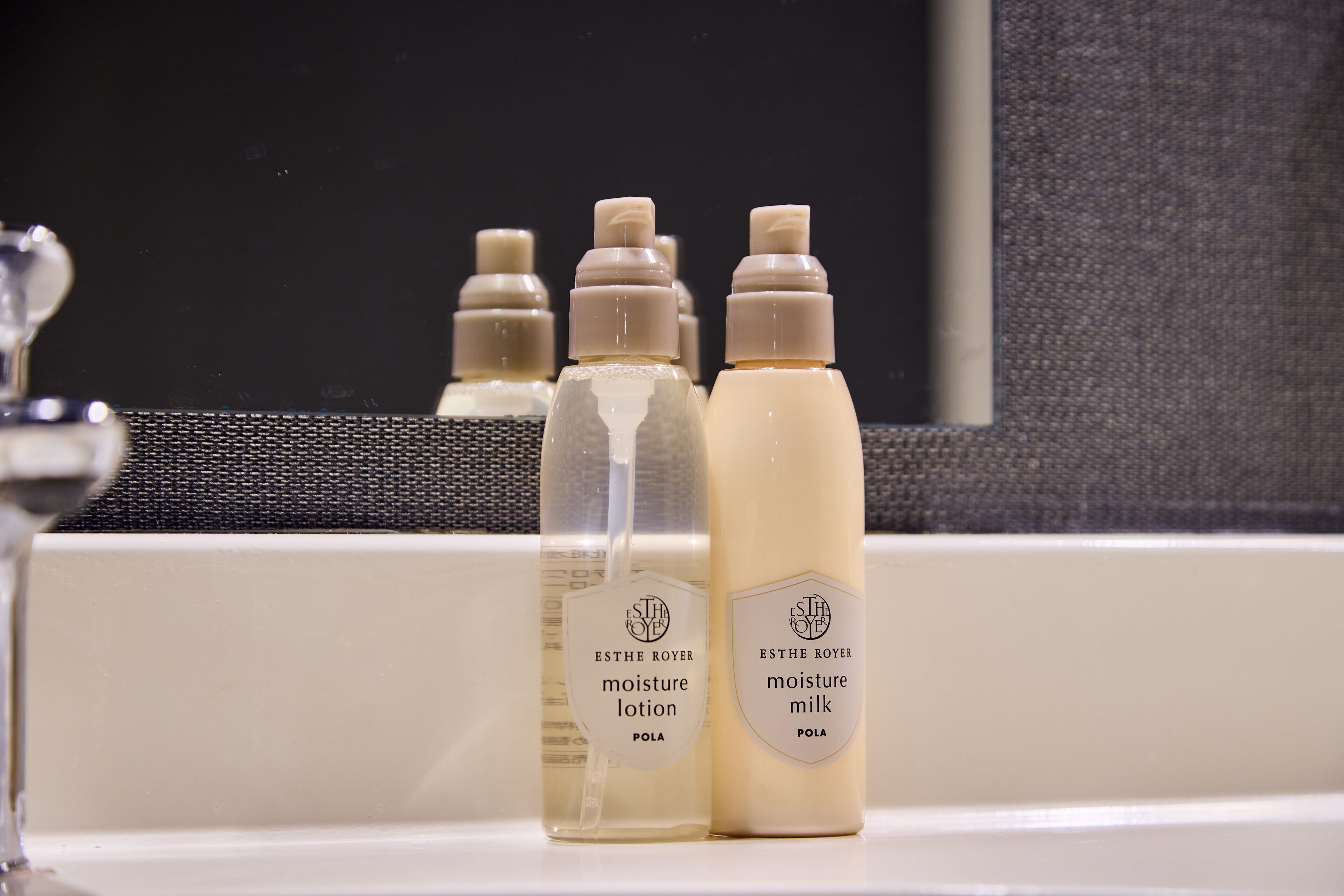 Tres botellas de productos ESTHE ROYER sobre una encimera de baño.