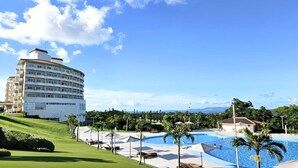 A resort with a large pool, a golf course, and a multi-story building with balconies. - ANA Crowne Plaza Resort Okinawa Uruma Hills by IHG (Uruma)