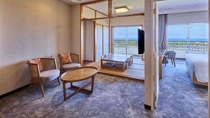 A hotel room with a balcony, a TV, and a seating area with a table and chairs. - ANA Crowne Plaza Resort Okinawa Uruma Hills by IHG (Uruma)