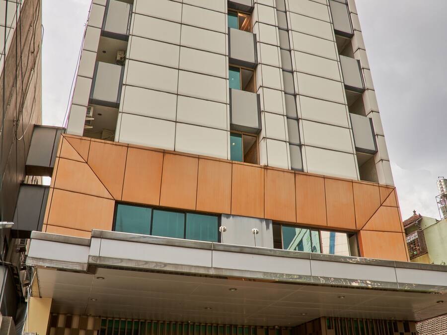 Ett hotell med en modern fasad, en framträdande skylt högst upp och en täckt entré med en vägg som har ett mönster.