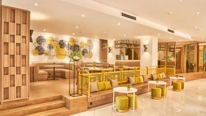A modern lobby with a seating area, a staircase, and a decorative wall. - Alia Boutique Pasar Baru (Jakarta)