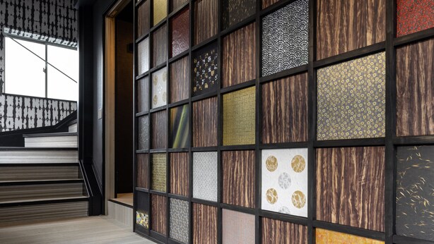 Una escalera de diseño moderno que conduce a una habitación con un gran muro estampado.
