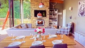 A dining area with a stone wall, a sofa, and a fireplace. - A yorkshire dale that sleeps 6 guests  in 3 bedrooms (Richmond)
