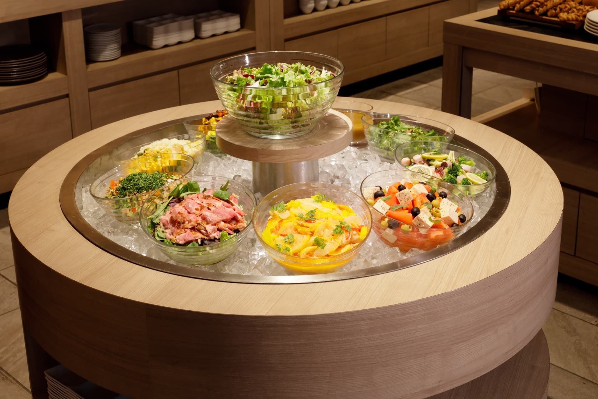 A buffet with various dishes on a glass tray.