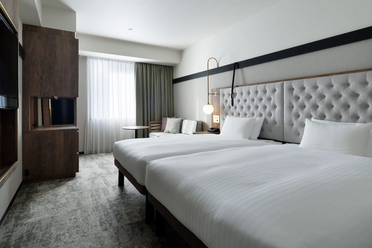 Une chambre d’hôtel avec un grand lit, un bureau, une chaise et un téléviseur.