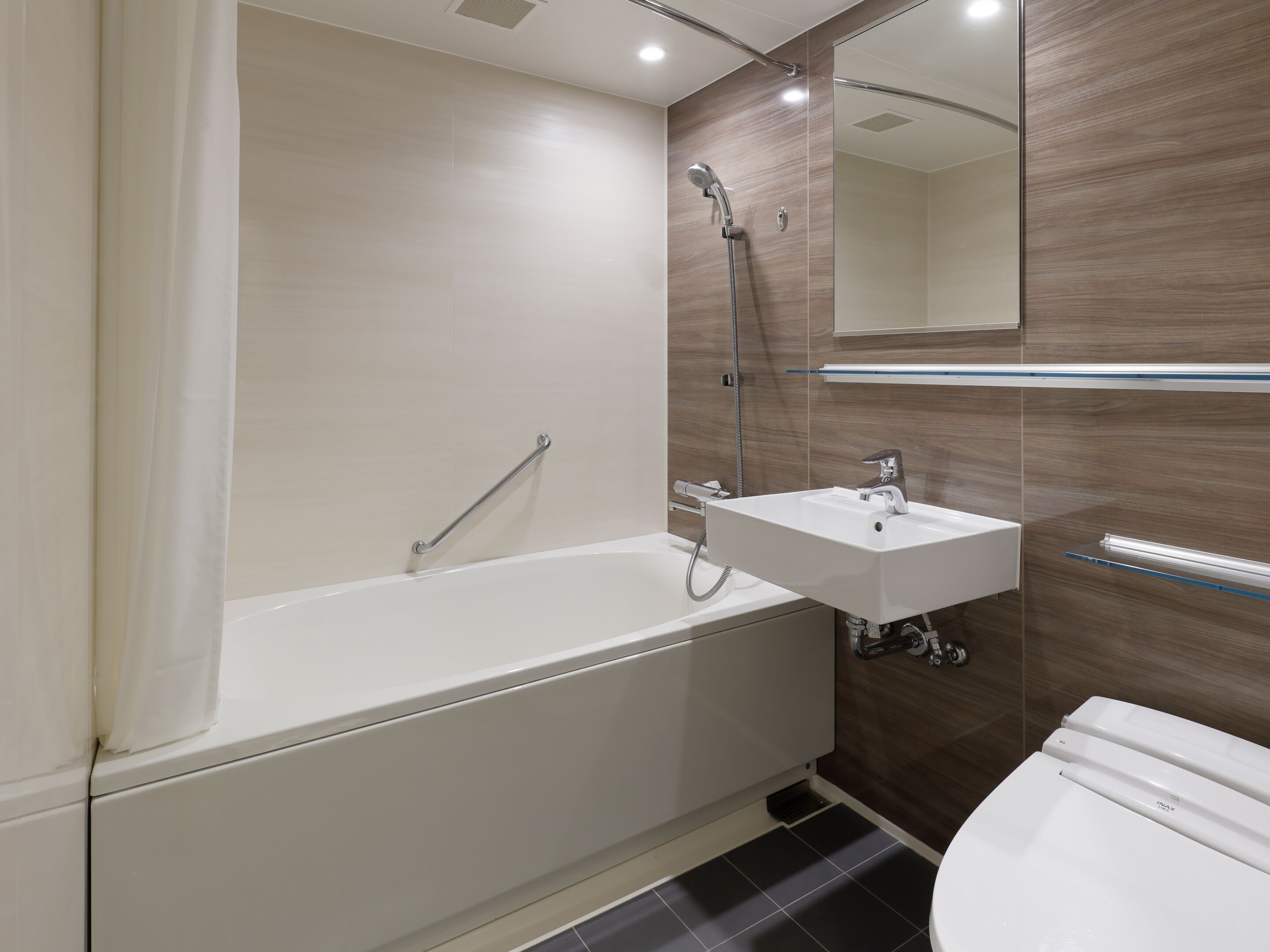 A modern bathroom with a bathtub, a sink, and a toilet.