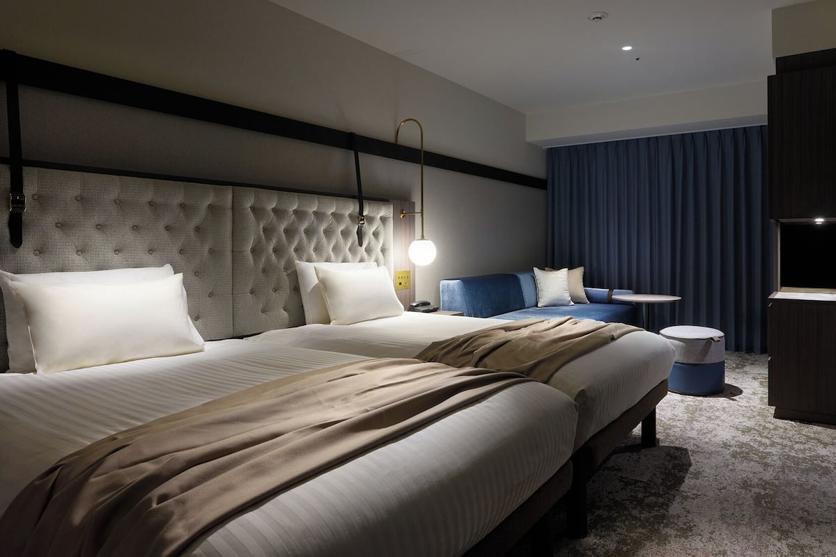 Ein Hotelzimmer mit einem großen Bett, einem Sofa, einem kleinen Tisch und einem Fernseher.