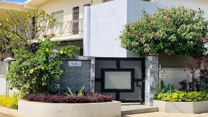 A modern house with a gated entrance, a balcony, and a well-maintained garden. - Anba's (Trou aux Biches)