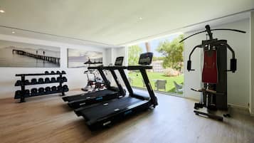A home gym with treadmills, dumbbells, and a weight machine.