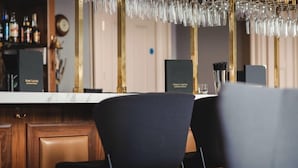 A bar area with a counter, bar stools, and a hanging light fixture. - A lews castle that sleeps 4 guests  in 2 bedrooms (Isle of Lewis)