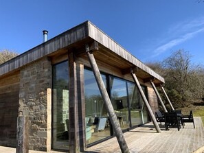 A modern house with large glass windows and a wooden deck.