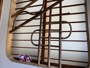 Une porte en métal avec un cadre en bois, un petit miroir et une paire de chaussons.