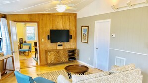Ein Wohnzimmer mit Holzwand, Fernseher, Sofa und Couchtisch.