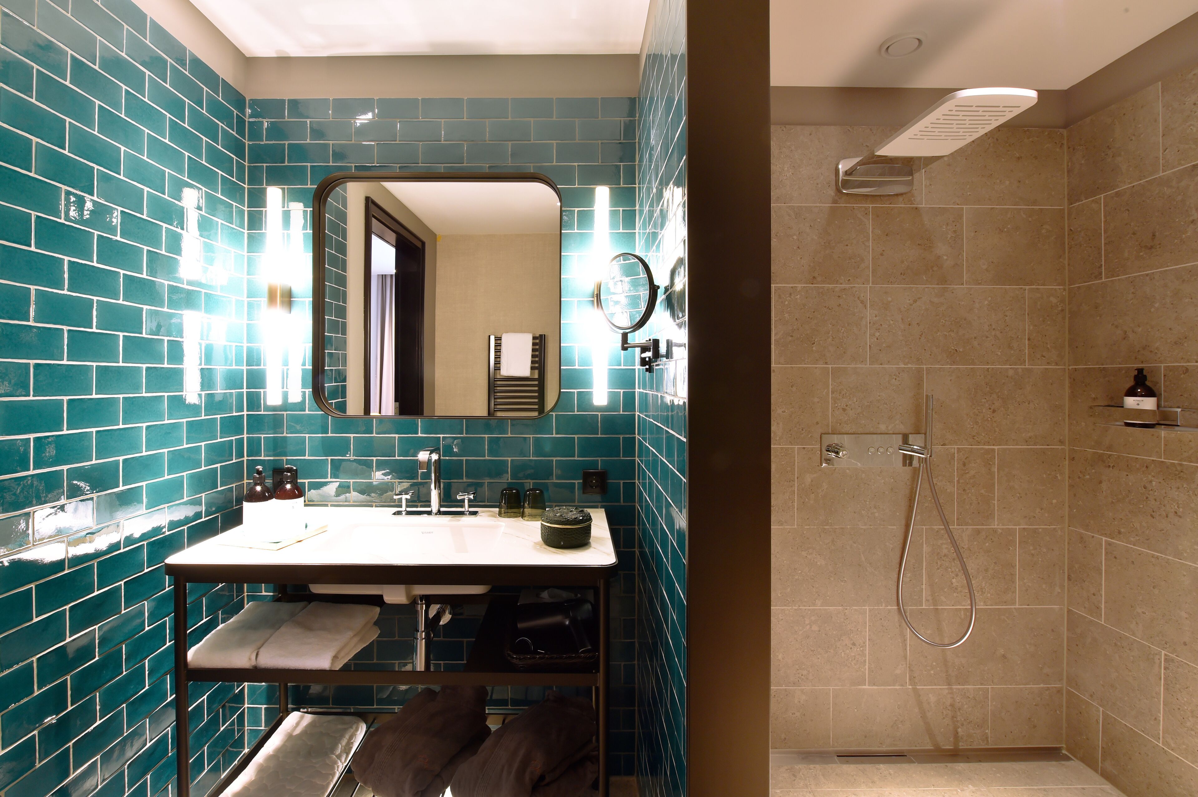 Un baño con lavamanos, espejo y ducha.