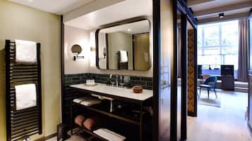 Un baño moderno con tocador de doble lavabo, un espejo grande y un perchero para toallas.