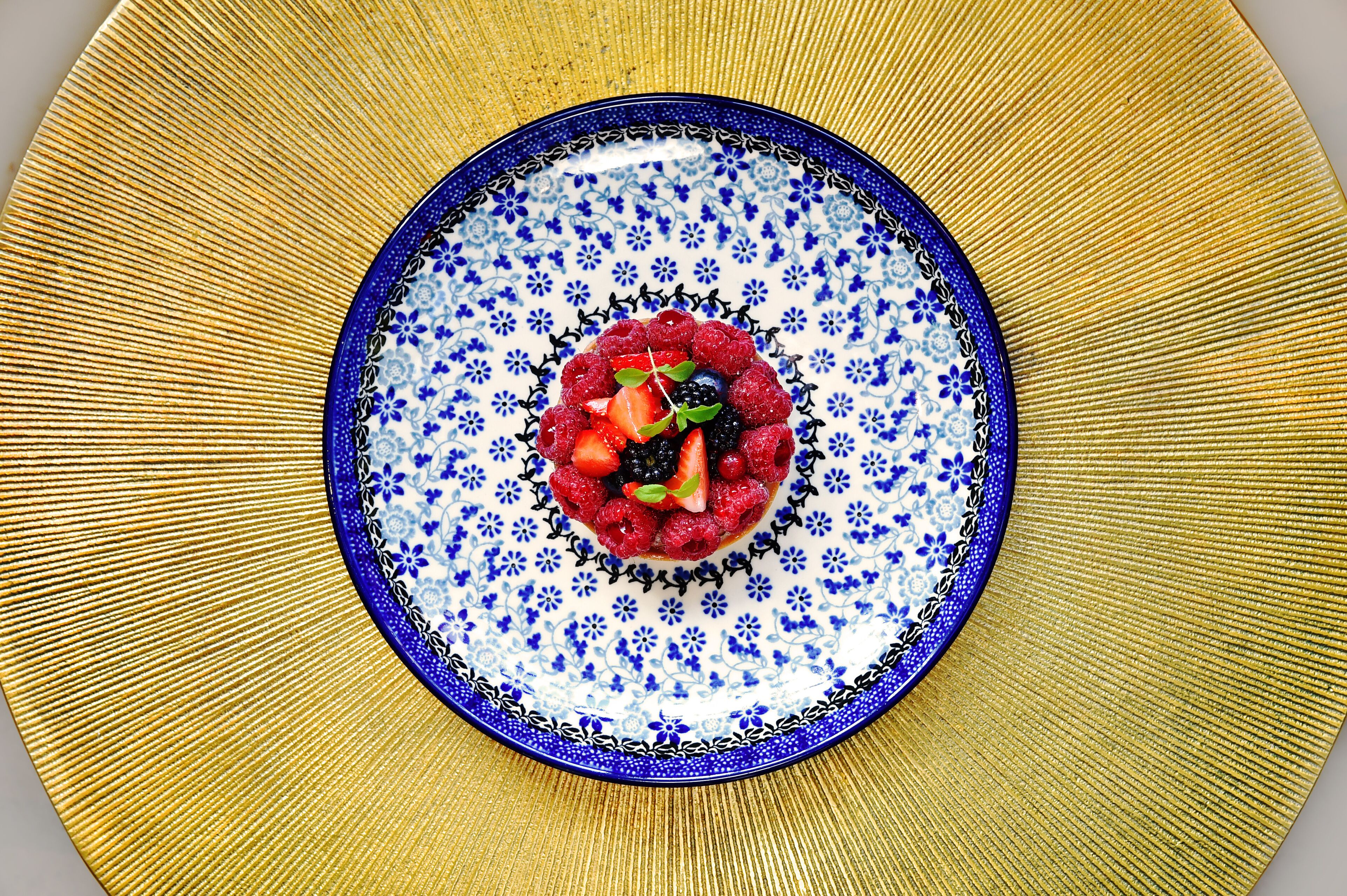 A plate with a blue floral pattern and a central berry mixture.