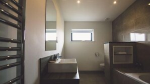 A bathroom with a sink, mirror, and window.