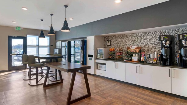 A modern kitchen with a coffee station, wooden flooring, and pendant lighting. - Extended Stay America Premier Suites Savannah Pooler (Pooler)