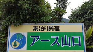 Ein Schild mit japanischem Text und ein Globus mit einem Baum, der einen Ort kennzeichnet.