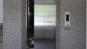 A modern elevator with a granite wall surrounding it. - Phu Xuan Hotel (Quy Nhon Nam)