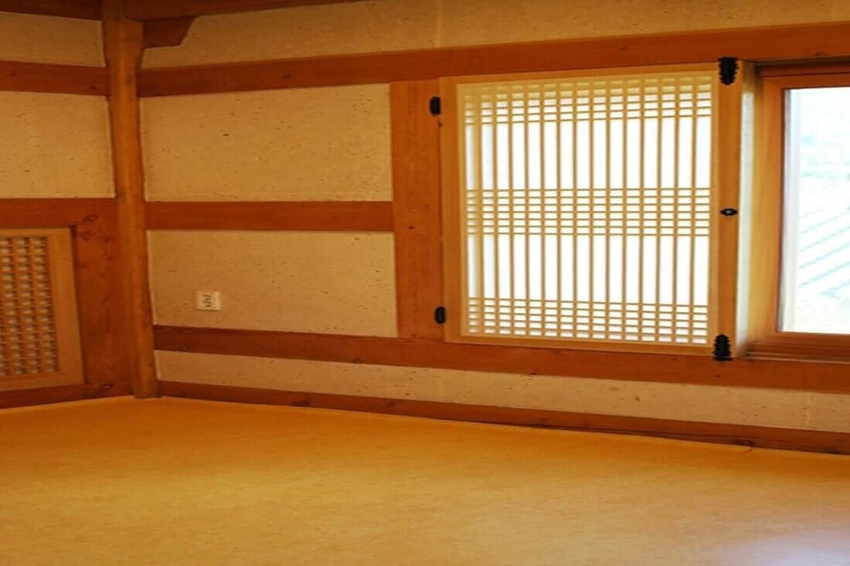 Une pièce de style japonais traditionnel, avec un sol recouvert de tatamis, des paravents shoji et des poutres en bois.