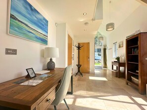 A hallway with a wooden desk, a chair, a coat rack, and a bookshelf. - Trewhiddle Villa 20 -  a trewhiddle that sleeps 6 guests  in 3 bedrooms (Saint Austell)