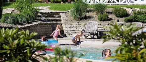 Piscine extérieure en saison, chaises longues