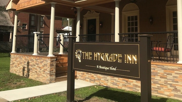 The Hygrade Inn, a boutique hotel with a covered porch and stone foundation. - The Hygrade Inn (Emporium)