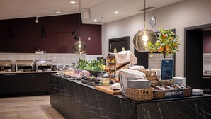 Een moderne keuken met marmeren aanrecht, een ontbijtbalk en diverse etenswaren.