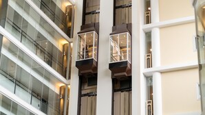 Een gebouw met meerdere verdiepingen, glazen balkonhekken en balkons.