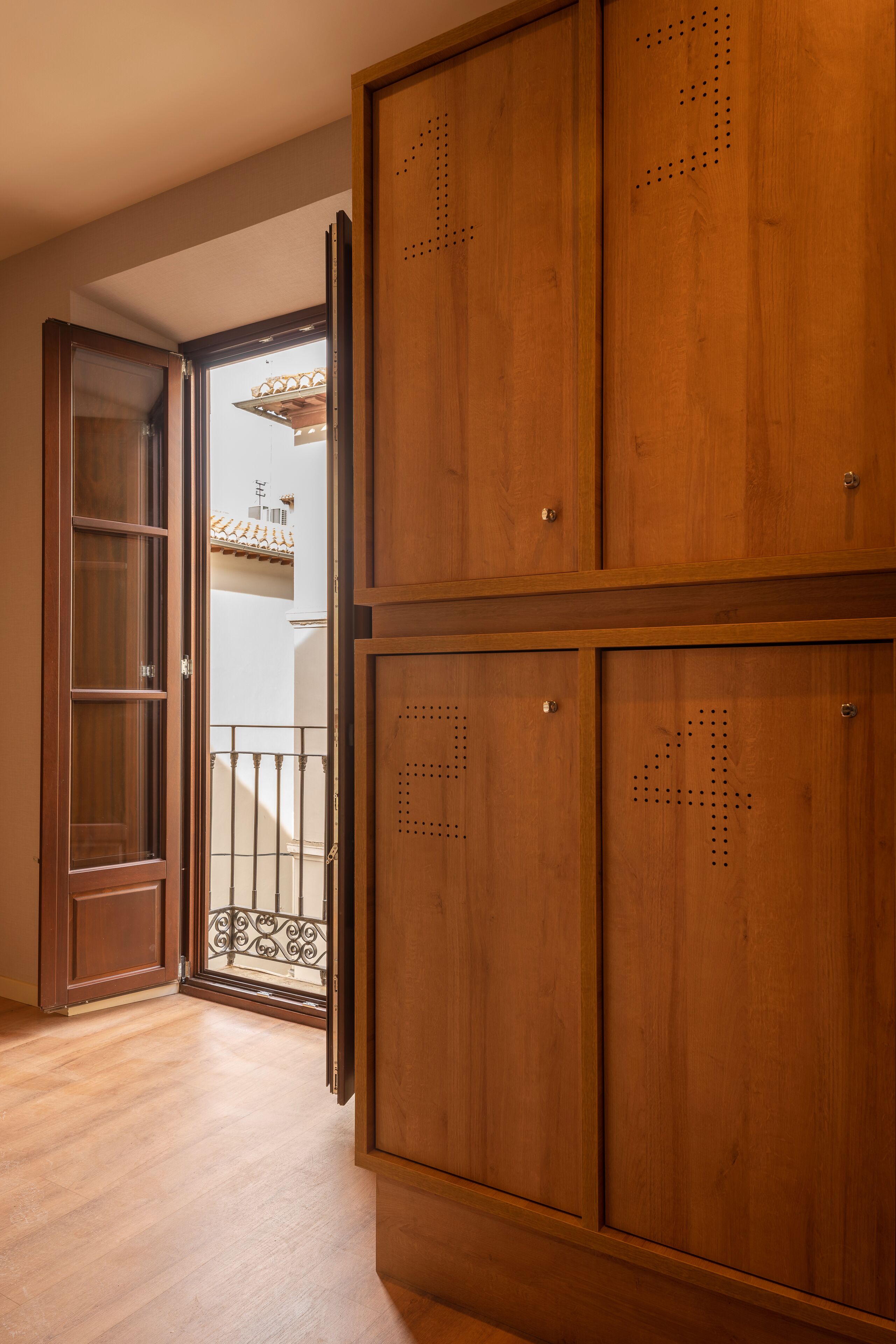 A wooden wardrobe with a balcony view.