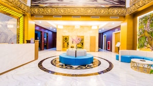 A lobby with a marble floor, a blue seating area, and a reception desk. - Hoa Dao Hotel (Hoa Binh)